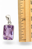 Making Waves Jewelry and Accessories rectangular faceted amethyst pendant in a 925 sterling silver bezel next to a ruler