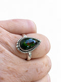 Making Waves Jewelry and Accessories teardrop Ammolite ring in sterling silver with rope detailing on a finger