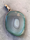 Making Waves Jewelry and Accessories banded agate pendant in sage green and grey with a sterling silver setting.
