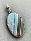 Making Waves Jewelry and Accessories oval banded agate pendant in a sterling silver bezel with a polished silver bail.