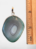 Making Waves Jewelry and Accessories banded agate pendant in sage green and grey with a sterling silver setting.