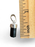 Making Waves Jewelry and Accessories raw black tourmaline crystal pendant with silver bail next to a ruler for scale.