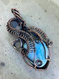 Making Waves Jewelry and Accessories handcrafted blue gemstone pendant in intricate oxidized copper wire wrapping.