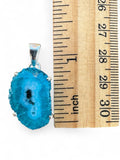 Making Waves Jewelry and Accessories blue druzy agate pendant in sterling silver setting next to a wooden ruler