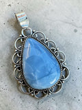 Making Waves Jewelry and Accessories teardrop blue opal pendant in a vintage sterling silver filigree frame.