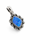 Making Waves Jewelry and Accessories blue opal pendant in a sterling silver frame with intricate scrollwork and beads.