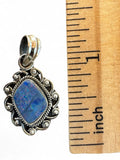 Making Waves Jewelry and Accessories blue opal pendant in a sterling silver frame with intricate scrollwork and rope trim