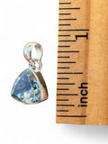 Making Waves Jewelry and Accessories trillion cut blue topaz pendant in sterling silver next to a ruler for scale