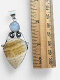 Making Waves Jewelry and Accessories sterling silver pendant with yellow calcite and moonstone next to a ruler.
