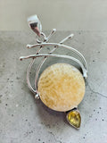 Making Waves Jewelry and Accessories artisan pendant featuring a circular golden calcite and pear yellow stone in silver