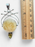 Making Waves Jewelry and Accessories sterling silver pendant with a circular golden calcite and pear-shaped yellow stone