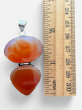 Making Waves Jewelry and Accessories sterling silver pendant with oval and teardrop carnelian stones next to a ruler.