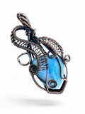Making Waves Jewelry and Accessories handcrafted blue gemstone pendant in intricate oxidized copper wire wrapping.