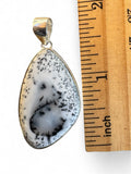Making Waves Jewelry and Accessories dendritic agate teardrop pendant in sterling silver next to a wooden ruler