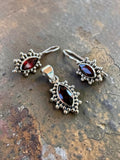 Making Waves Jewelry and Accessories garnet and sterling silver pendant and drop earring set with beaded borders.