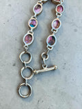Making Waves Jewelry and Accessories sterling silver link bracelet with oval magenta and copper gemstone cabochons.