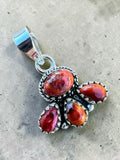 Making Waves Jewelry and Accessories sterling silver pendant with four polished red and orange sunset-hued gemstones.