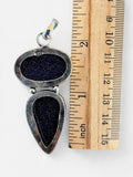 Making Waves Jewelry and Accessories double stone goldstone pendant in 925 sterling silver next to a wooden ruler.