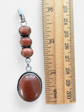 Making Waves Jewelry and Accessories sterling silver pendant with four oval goldstone cabochons and rope detailing.