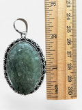 Making Waves Jewelry and Accessories oval green rutilated quartz pendant with ornate sterling silver scalloped setting