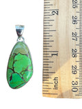 Making Waves Jewelry and Accessories green turquoise teardrop pendant in a 925 sterling silver setting next to a ruler.