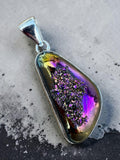Making Waves Jewelry and Accessories iridescent druzy crystal pendant in sterling silver with purple and gold tones.