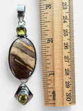 Making Waves Jewelry and Accessories oval jasper pendant with citrine accents in 925 sterling silver next to a ruler.
