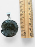 Making Waves Jewelry and Accessories labradorite ammonite pendant in a sterling silver rope setting next to a ruler.