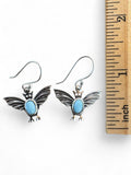 Making Waves Jewelry and Accessories sterling silver bat dangle earrings with sky-blue Larimar cabochons next to a ruler