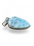 Making Waves Jewelry and Accessories teardrop Larimar pendant with silver filigree bail and oceanic blue patterns.
