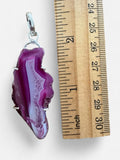 Making Waves Jewelry and Accessories magenta agate slice pendant in a sterling silver setting next to a ruler