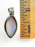 Making Waves Jewelry and Accessories marquise spiny oyster shell pendant in a sterling silver bezel next to a ruler