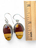 Making Waves Jewelry and Accessories oval Mookaite Jasper drop earrings in sterling silver settings next to a ruler.