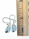Making Waves Jewelry and Accessories teardrop moonstone earrings in sterling silver next to a wooden ruler for scale.