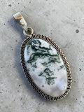 Making Waves Jewelry and Accessories oval moss agate pendant in a decorative sterling silver wire-work bezel setting.