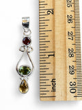 Making Waves Jewelry and Accessories sterling silver pendant with garnet, peridot, and citrine gemstones next to ruler