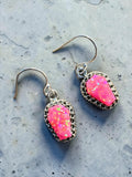 Making Waves Jewelry and Accessories neon pink coffin-shaped dangle earrings with iridescent stones and silver settings.
