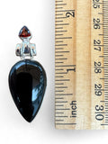 Making Waves Jewelry and Accessories teardrop pendant with black onyx and garnet in 925 sterling silver next to a ruler