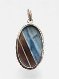 Making Waves Jewelry and Accessories oval banded agate pendant in a sterling silver bezel with textured edge detail.