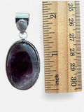 Making Waves Jewelry and Accessories oval amethyst pendant in sterling silver with a small accent stone next to a ruler
