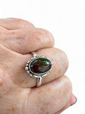 Making Waves Jewelry and Accessories oval ammolite ring in sterling silver with etched bezel on a hand