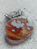 Making Waves Jewelry and Accessories oval jasper pendant with red, ochre, and grey patterns and filigree metal bail.