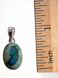 Making Waves Jewelry and Accessories oval doublet opal pendant in sterling silver bezel next to a wooden ruler