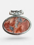 Making Waves Jewelry and Accessories oval pendant featuring a polished terracotta, cream, and grey stone in silver.