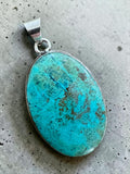 Making Waves Jewelry and Accessories oval turquoise pendant with natural matrix patterns in a polished sterling silver bezel