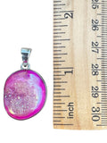 Making Waves Jewelry and Accessories hot pink druzy oval pendant in 925 sterling silver next to a ruler for scale