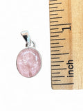 Making Waves Jewelry and Accessories oval pink gemstone pendant in sterling silver bezel setting next to a ruler