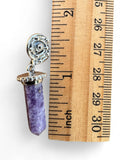 Making Waves Jewelry and Accessories purple crystal point pendant with silver spiral setting next to a wooden ruler