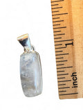 Making Waves Jewelry and Accessories rectangular moonstone pendant in a sterling silver bezel next to a ruler