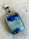 Making Waves Jewelry and Accessories rectangular pendant featuring a blue and grey stone in a beaded sterling silver bezel